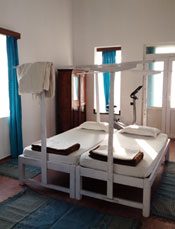 A twin room with white four-poster beds