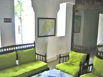 Wooden sofas with green cushions in the hall