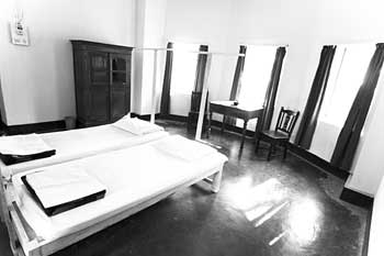 A twin room with tall windows, in black and white